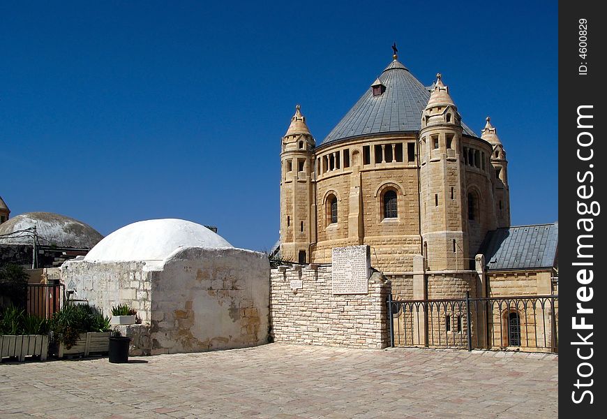 The Neo-Romanesque dome of the Church of Dormition, on Mount Zion in Jerusalem, from seen from the rooftops of the Hall of the Last Supper and King David's Tomb. Current shape of the church dates to the 20th century, but stands on the site where the Virgin Mary is said to have fallen into an eternal sleep. The Neo-Romanesque dome of the Church of Dormition, on Mount Zion in Jerusalem, from seen from the rooftops of the Hall of the Last Supper and King David's Tomb. Current shape of the church dates to the 20th century, but stands on the site where the Virgin Mary is said to have fallen into an eternal sleep.