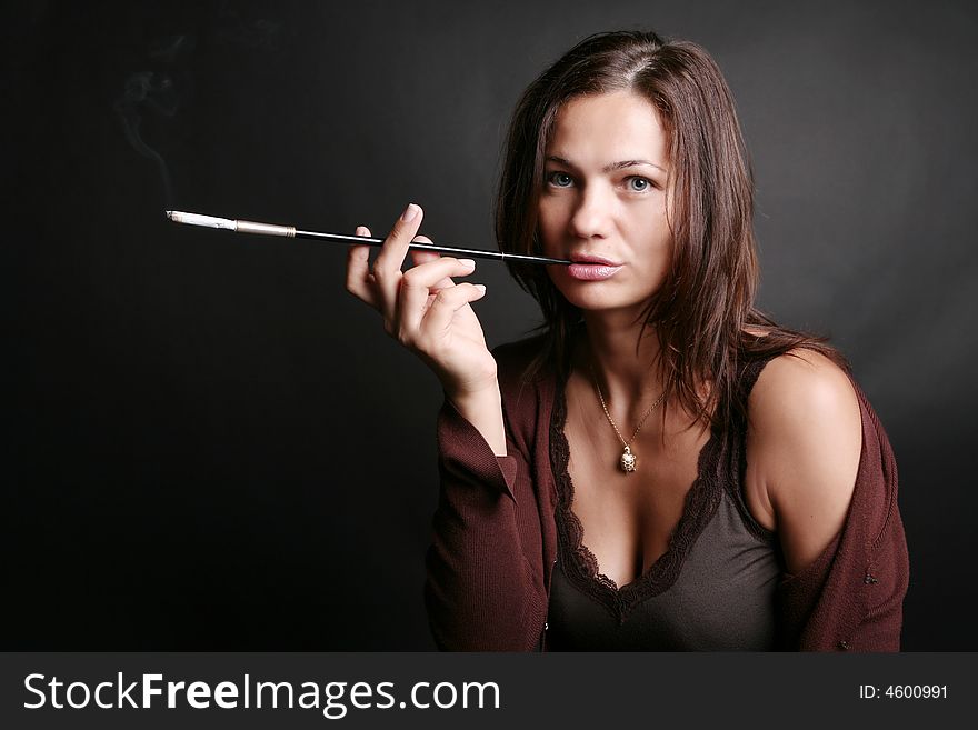 Portrait of a smoking woman on black background. Portrait of a smoking woman on black background