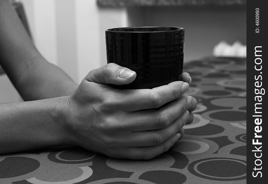 A couple of hands holding a coffemug. A couple of hands holding a coffemug