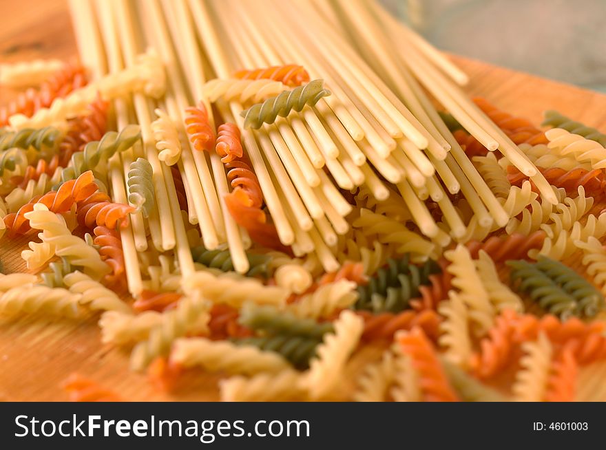 Raw colour pasta background on yellow cook-table. Raw colour pasta background on yellow cook-table