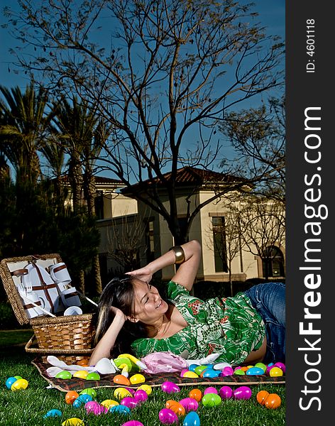Asian female with her hands on her head laying on a picnic blanket. Asian female with her hands on her head laying on a picnic blanket