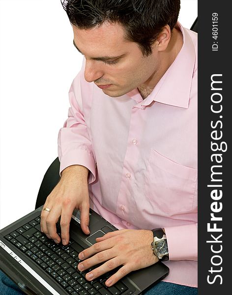 A man, sitting in his chair, holding a laptop computer on his knees, in the middle of some serious working. A man, sitting in his chair, holding a laptop computer on his knees, in the middle of some serious working