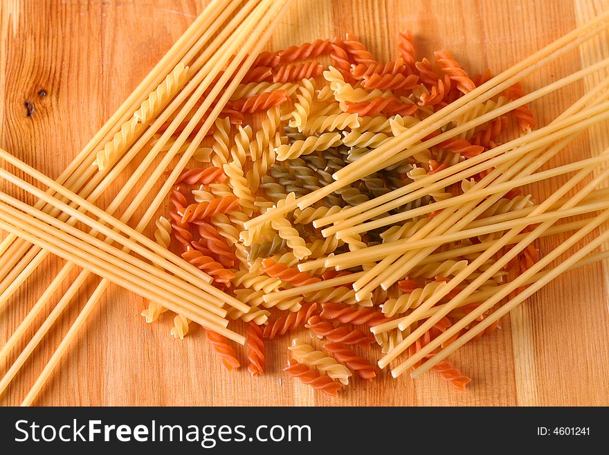 Raw colour pasta background on yellow wooden cook-table. Raw colour pasta background on yellow wooden cook-table