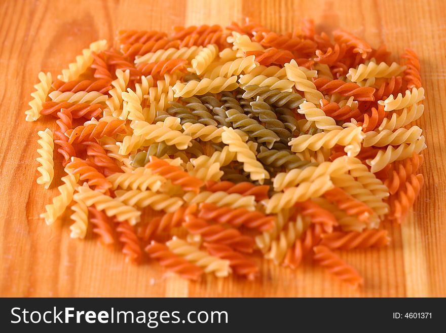 Raw colour pasta background on yellow wooden cook-table. Raw colour pasta background on yellow wooden cook-table