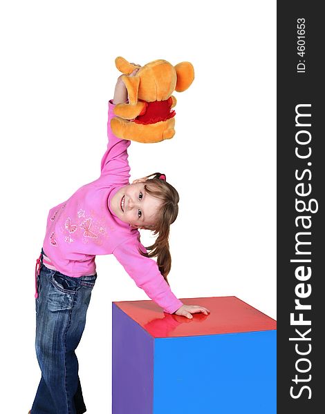 The child near a multi-coloured cube holds a toy in a hand. The child near a multi-coloured cube holds a toy in a hand