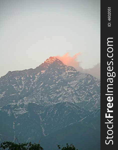 Red glowing like a flame sunset light on dhauladhar himalayan mountain ranges in Kangra India. Red glowing like a flame sunset light on dhauladhar himalayan mountain ranges in Kangra India