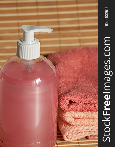 Pink container with hand pump and towels. Pink container with hand pump and towels