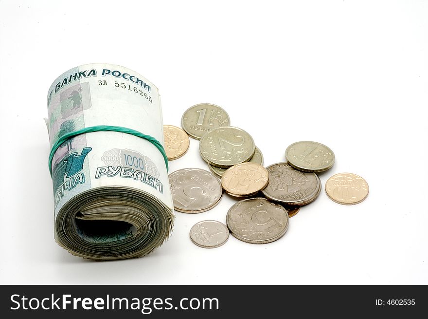 The banknotes braided in a roll and coins on a white background