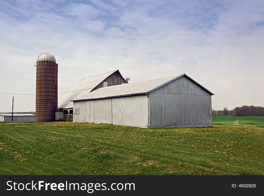 White barn on farm with silo.