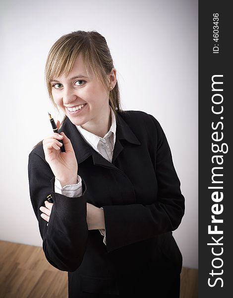 An attractive working woman with pen in the hand.