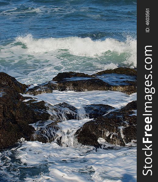 Pacific ocean waves breaking on beach rocks. Pacific ocean waves breaking on beach rocks