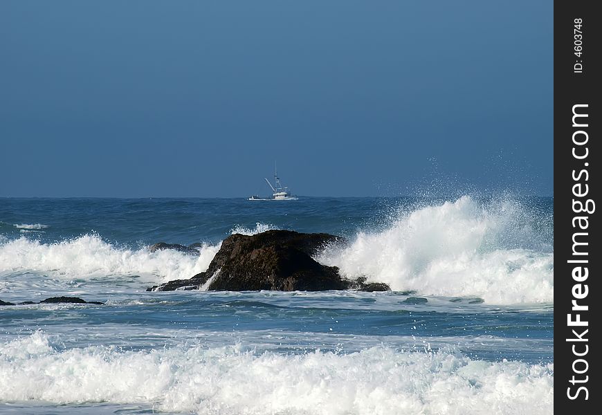 Fishing trawler heading out with ocean waves in forground. Fishing trawler heading out with ocean waves in forground