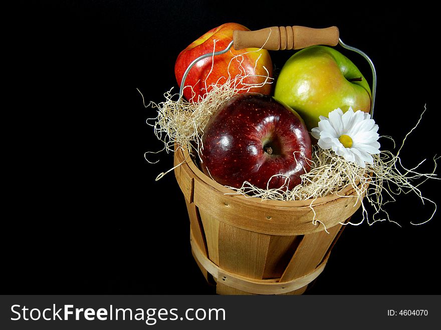 Variety of polished apples in a basket with a daisy. Variety of polished apples in a basket with a daisy.