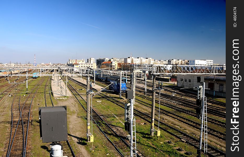 Railway Station in bright sunlight with train departing