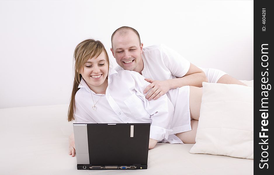 Smiling couple with laptop on a couch. Relax at home. Smiling couple with laptop on a couch. Relax at home.