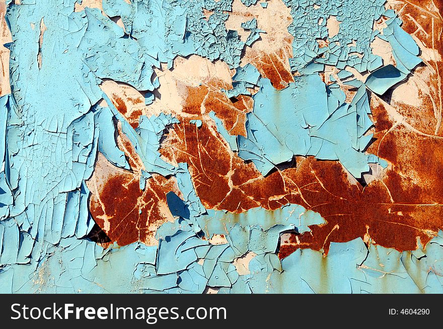 Paint peeling from a blue rusted metal object. Paint peeling from a blue rusted metal object