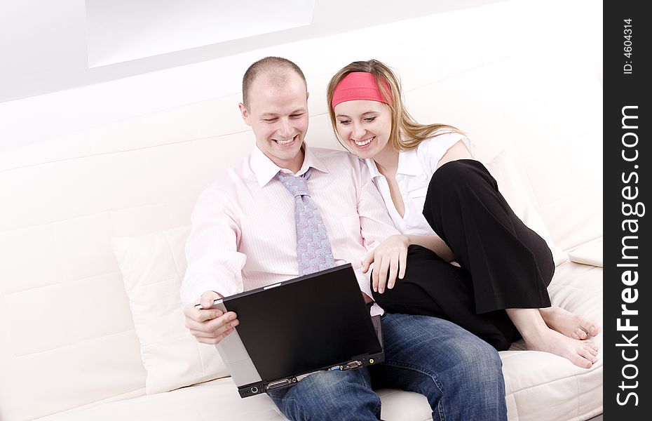 Smiling couple with laptop on a couch. Relax at home. Smiling couple with laptop on a couch. Relax at home.