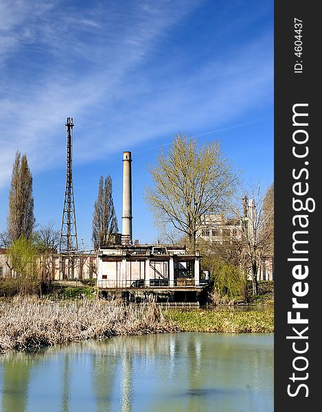 A view with a industrial facility and water reflection