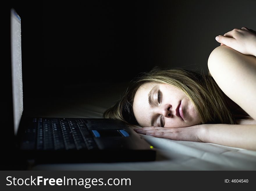 Young woman takes a break and sleeps on the couch, front of her laptop. Young woman takes a break and sleeps on the couch, front of her laptop