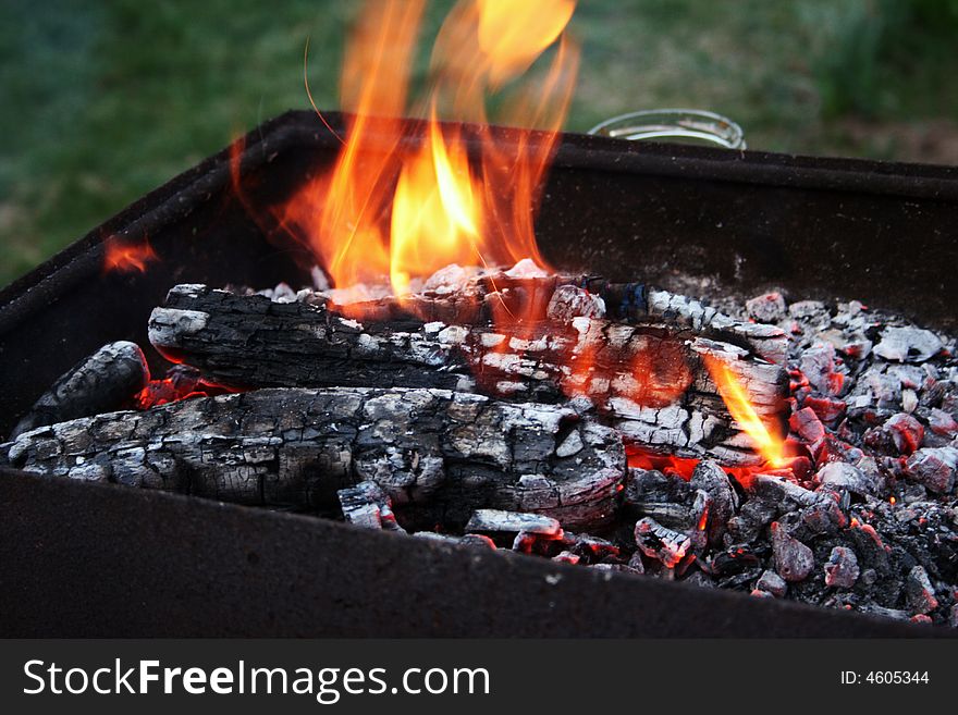 Picnic barbecue charcoals burning brightly in outdoor setting. Picnic barbecue charcoals burning brightly in outdoor setting.