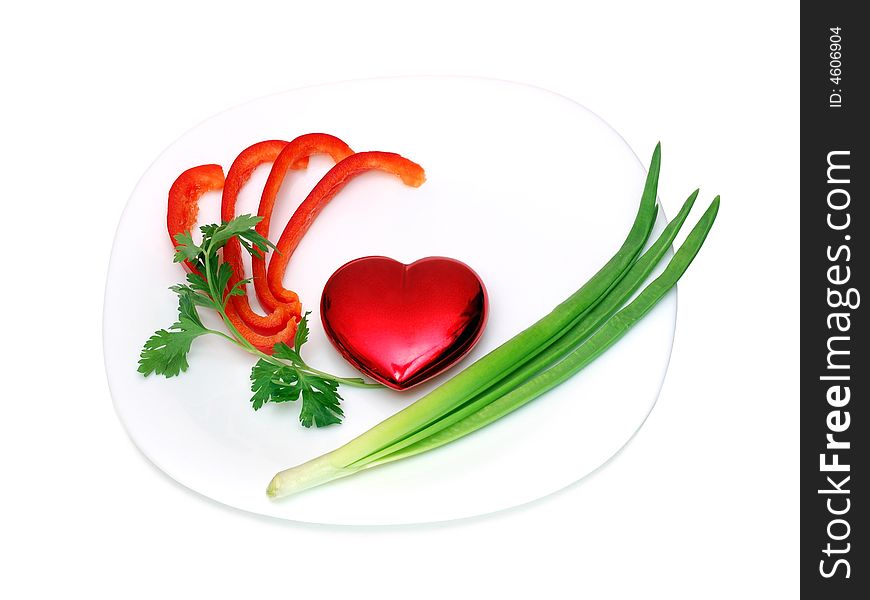 Toy heart on a plate isolated over a white background