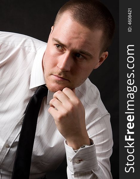 Portrait of a young businessman on black background