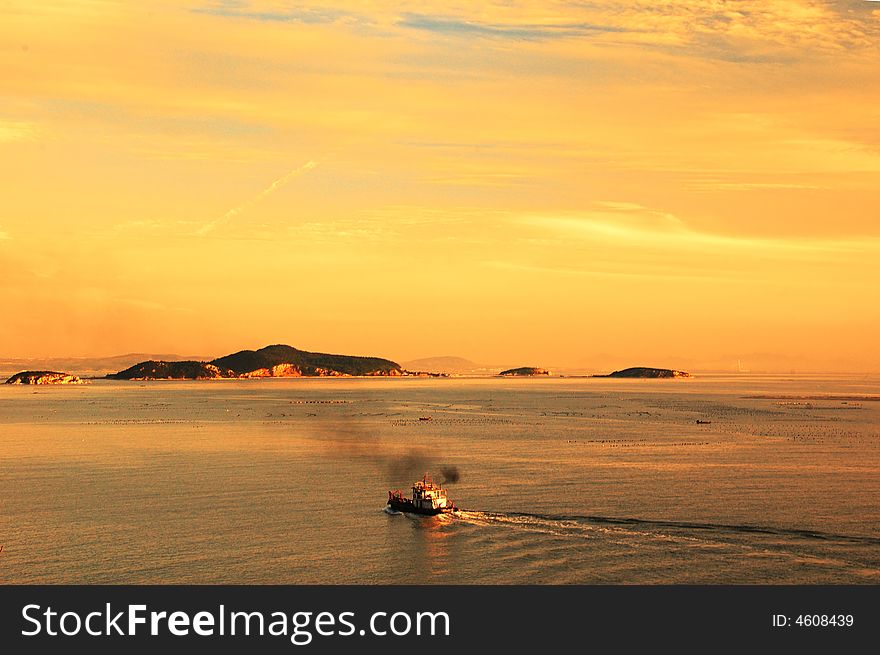 Under the setting sun shining day of the completion of the fishing vessel back to port. Under the setting sun shining day of the completion of the fishing vessel back to port