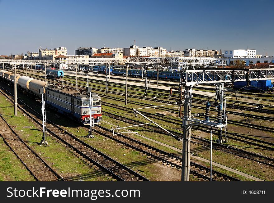 Railway Station in bright sunlight with train departing