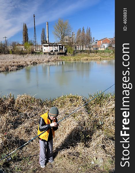 Little boy fishing in an industrial waste waters.