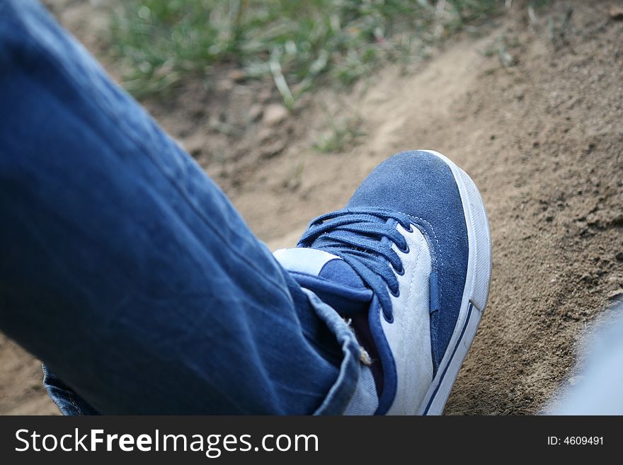A blue shoe with shoelaces, natural background