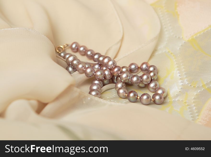Beautiful pearls on the beige scarf
