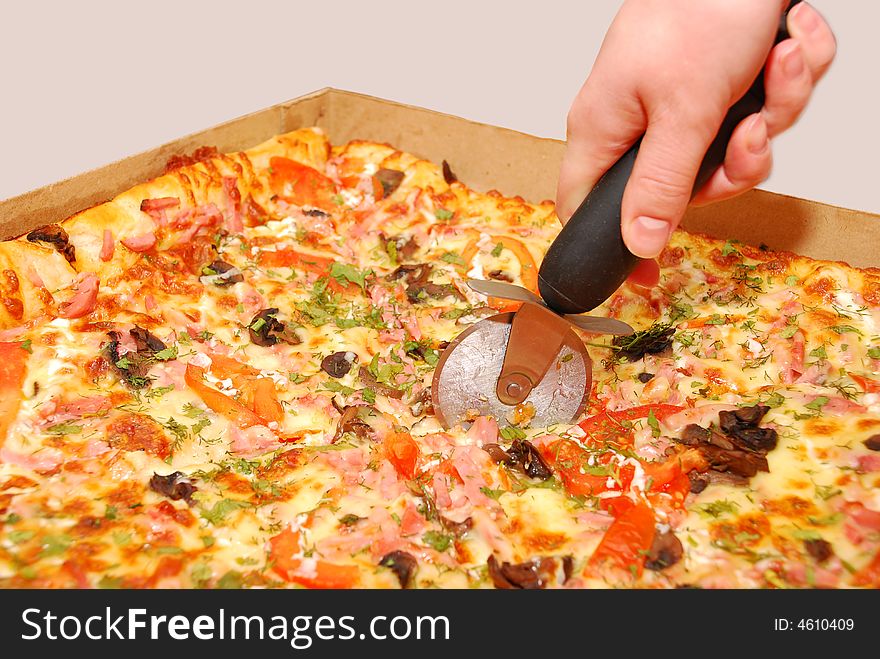 Female hand cutting pizza on white background. Female hand cutting pizza on white background