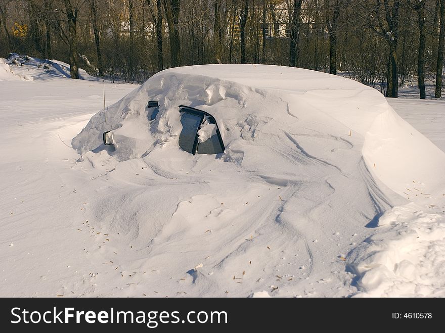 Car covered with snow in winter blizzard snowdrift