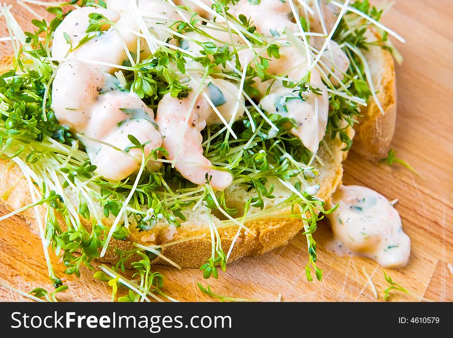 Prawn and cress open sandwich on a wooden table