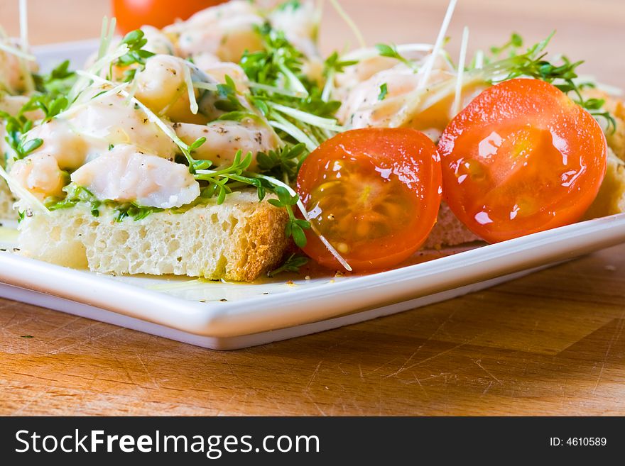 Prawn, cress and tomato sandwich on a white plate