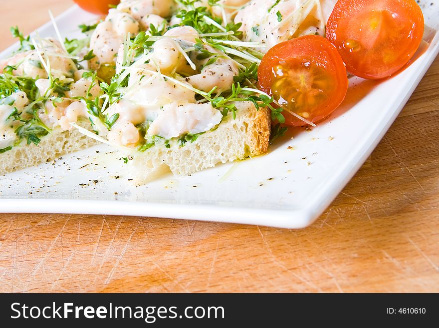 An open seafood sandwich with tomatoes