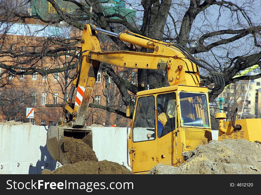 Large excavator moving sand for road construction