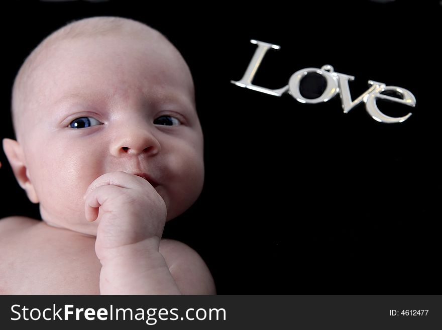 Newborn Baby on black Background with word LOVE. Newborn Baby on black Background with word LOVE