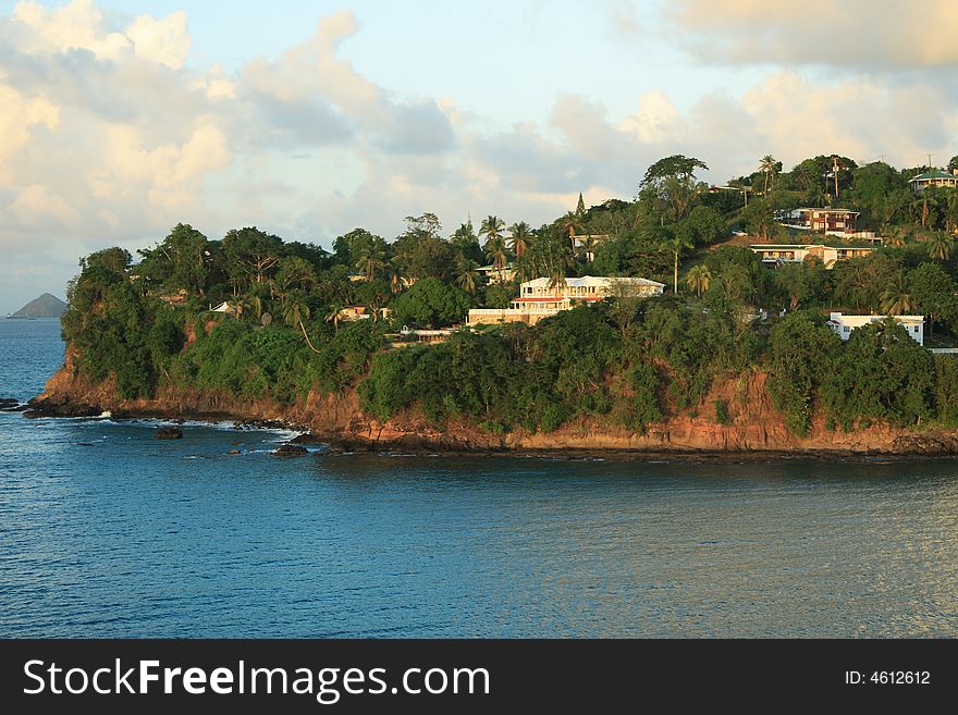 Tropical houses on hill overlooking harbor entrance