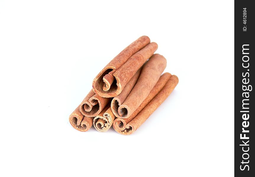 Dry cinnamon sticks tower on a white background