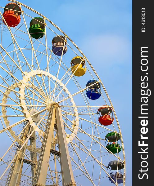 Big ferris wheel with colored cabins on cloudy sky. Big ferris wheel with colored cabins on cloudy sky