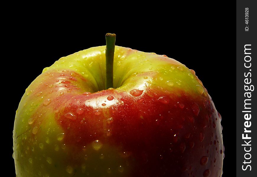 Fresh apple with drops of water on black background