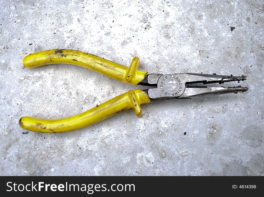 Yellow Pliers on Concrete Wall