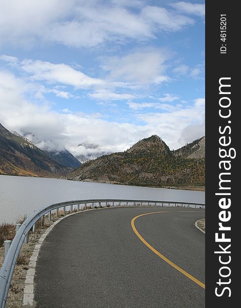 Make a right turn bysides the lake at the tibet under the clear sky