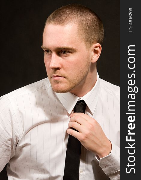 Portrait of a young businessman on black background