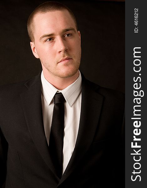 Portrait of a young businessman on black background