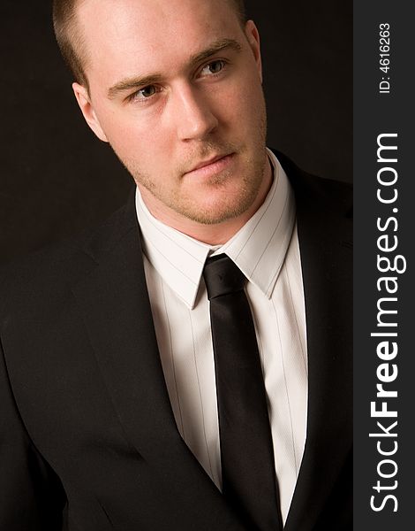 Portrait of a young businessman on black background