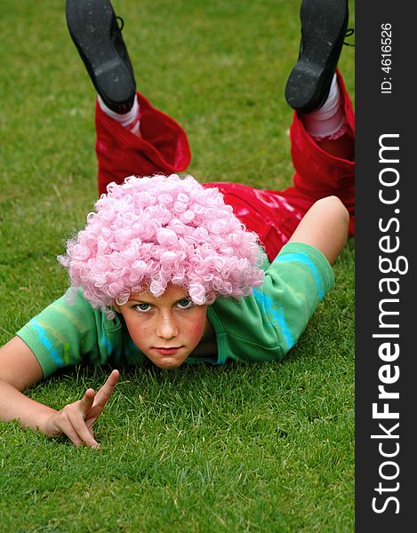 Natural portrait of girl lying in grass giving peace sign. Natural portrait of girl lying in grass giving peace sign