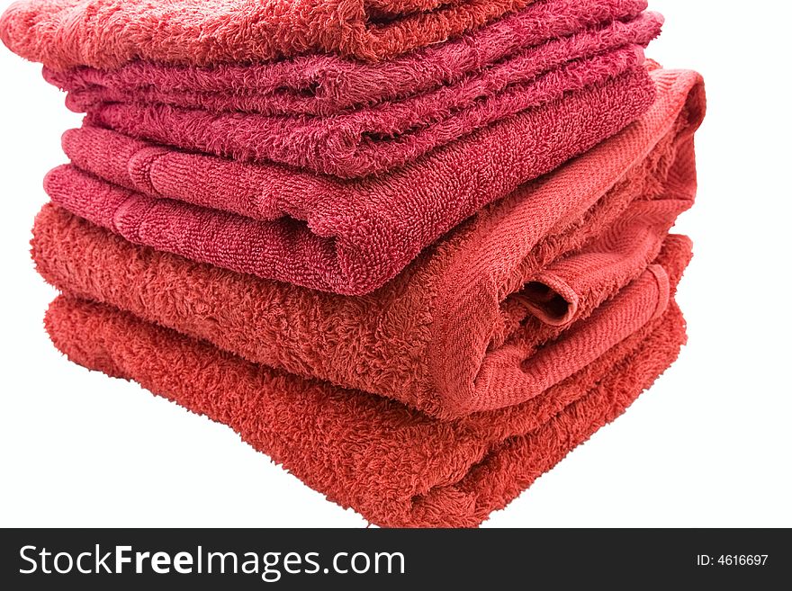 A stack of red bath towels against a white background