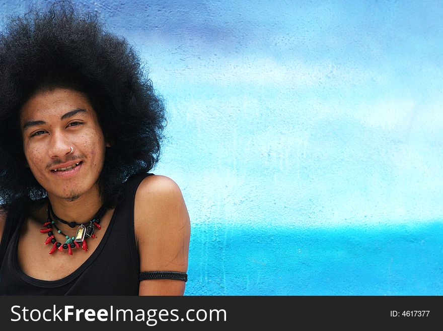 Thai man with a big afro hairstyle and fang teeth.